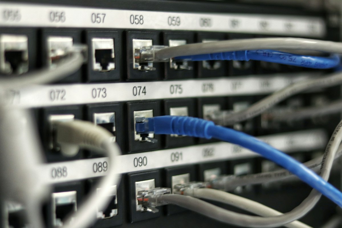 Aisle of a data center server facility with high-performance computing racks and network cables